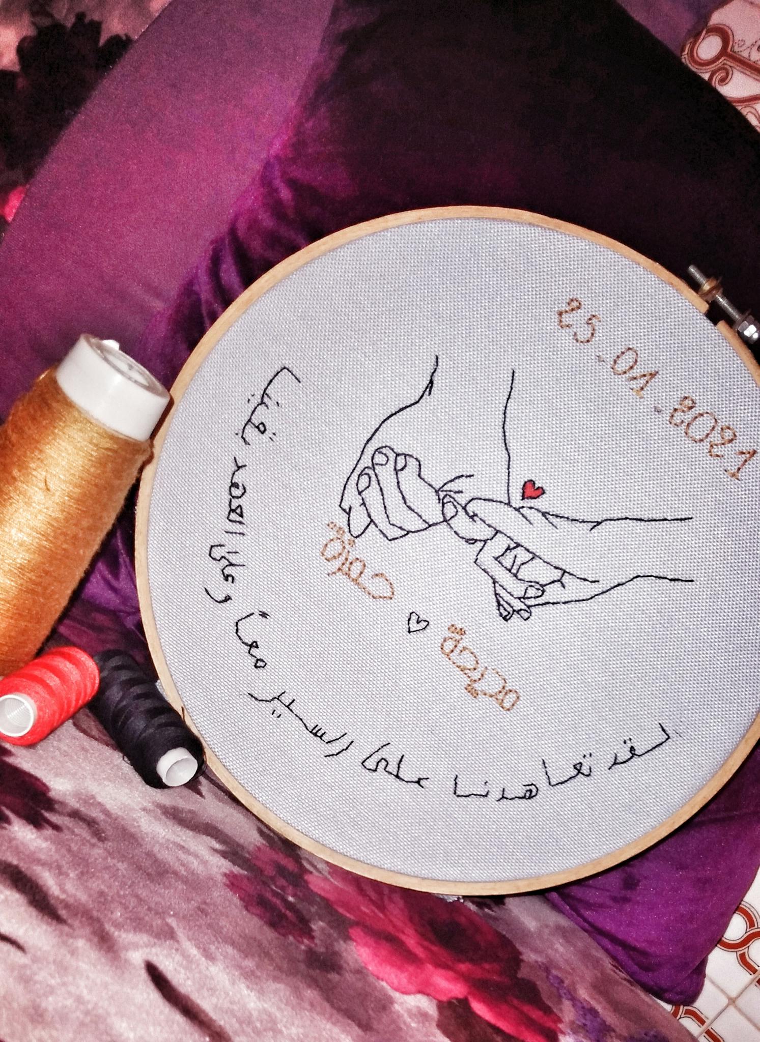 Beautiful hand embroidery depicting love and connection with Arabic text and date.